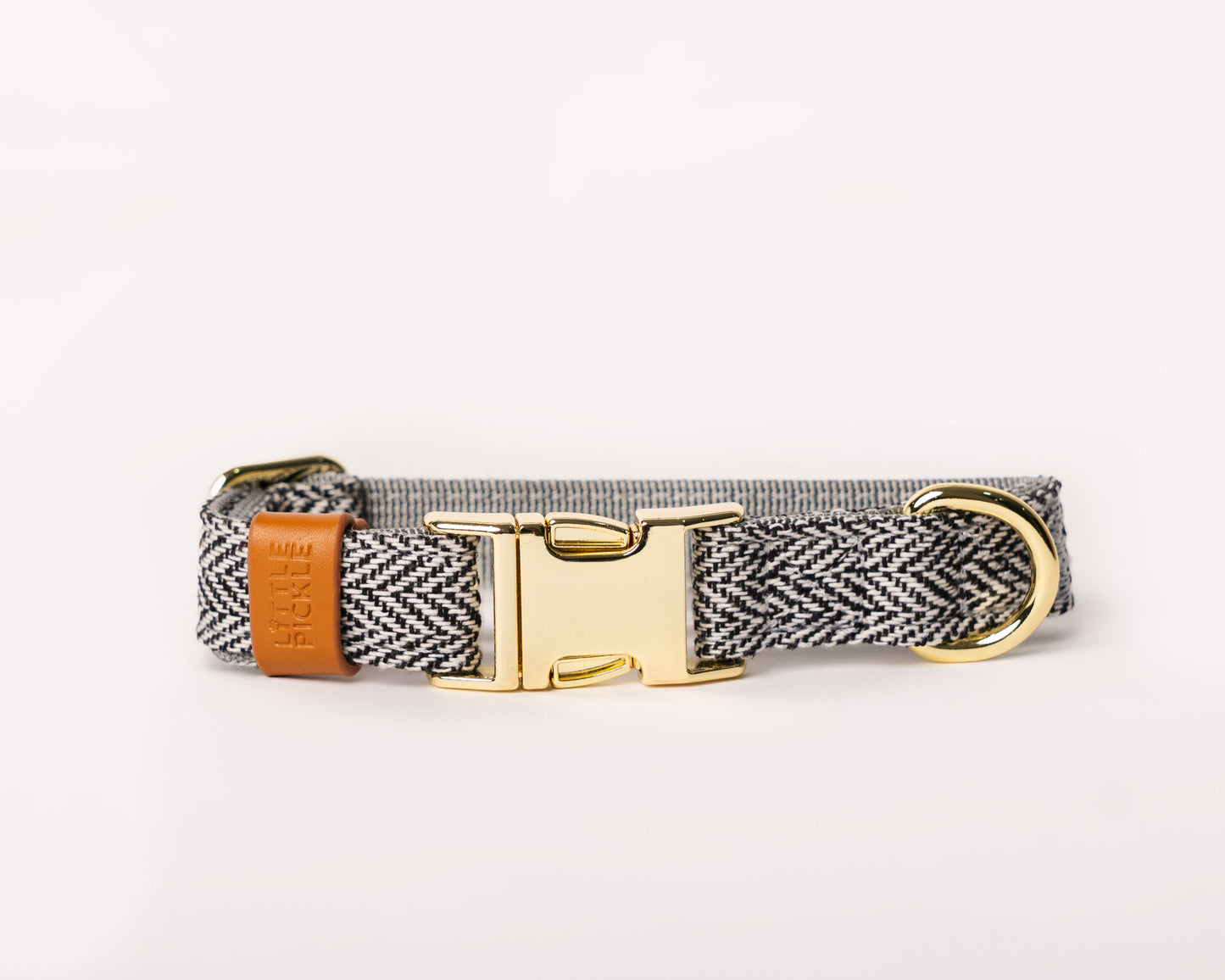 Dog collar with herringbone pattern, brown leather strap, and gold buckle on a white background