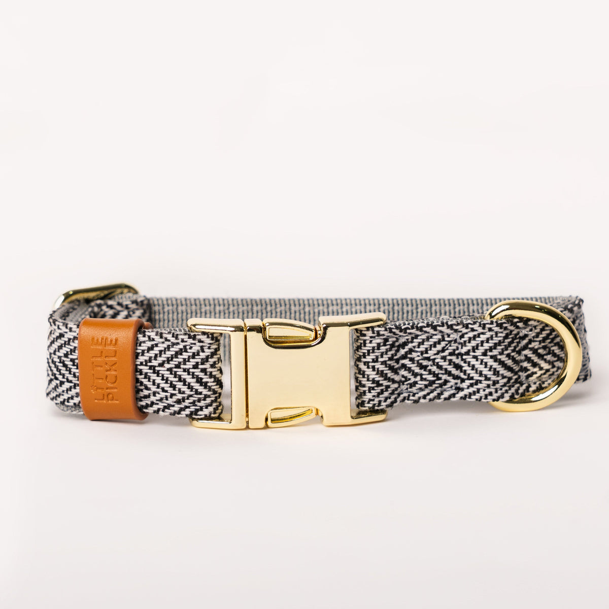 Dog collar with herringbone pattern, brown leather strap, and gold buckle on a white background