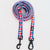 A coiled dog leash with a red, white, and blue gingham pattern, featuring black metal swivel clamps on a plain white background.