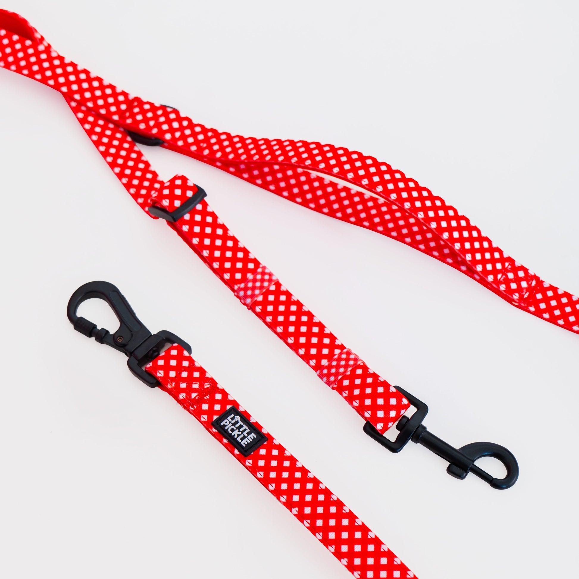 Red and white gingham patterned dog leash with black metal hardware and a small black brand tag reading 'LITTLE PICKLE'.